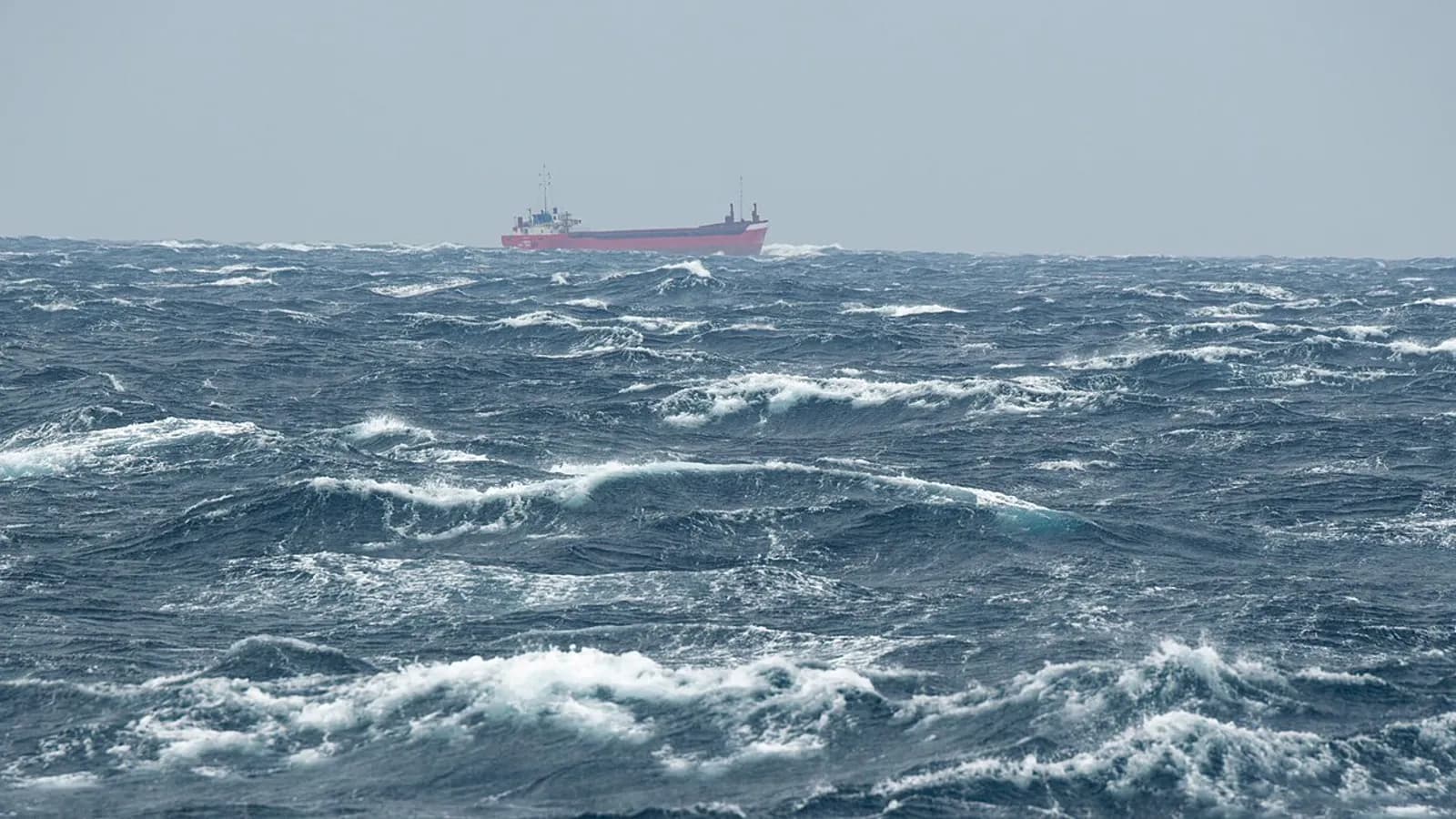 A general cargo vessel making way through a heavy following sea