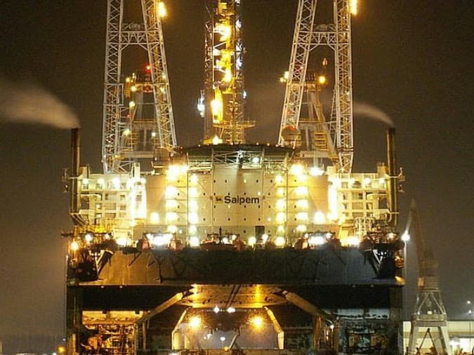 Semi-submersible crane vessel alongside at night under working lights
